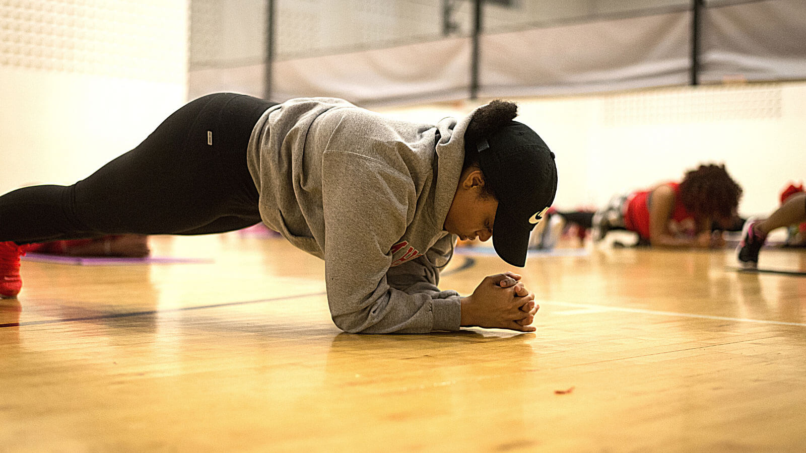 Mujer sosteniendo una tabla durante un entrenamiento cardiovascular y de fuerza